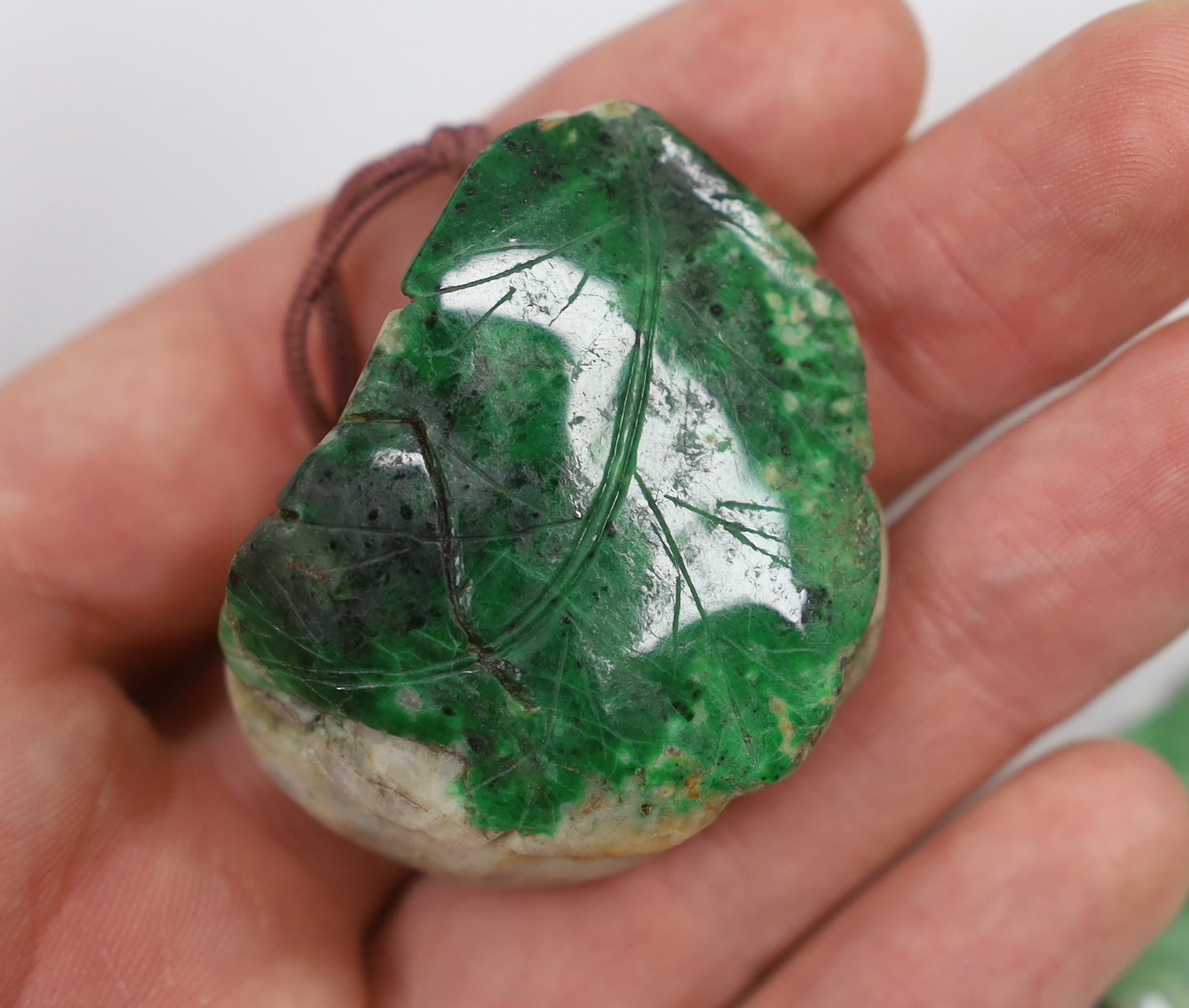 Two jadeite pendants and a handle tip
